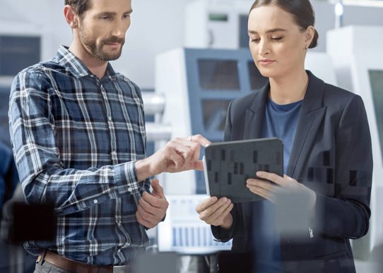 En kvinde og mand står med tablet i hånden
