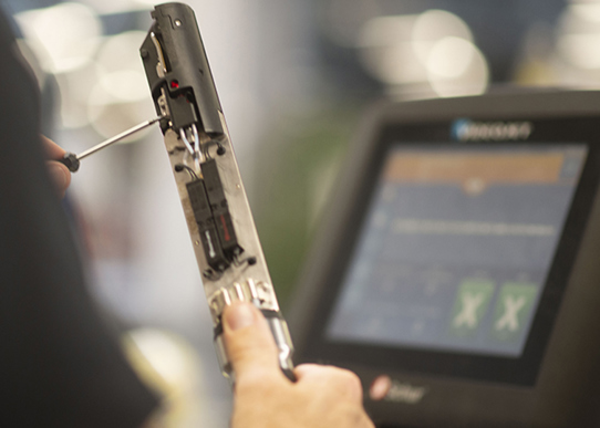 Mand med skruetrækker der arbejder på en maskine